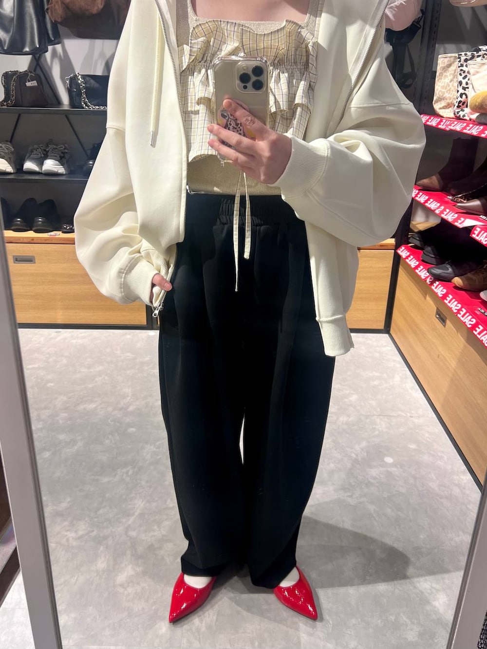 ブラック系のスウェットパンツ、ゴールド系のタンクトップ、ベージュ系のパーカーを着用したレディースの冬コーディネートの7枚目の写真