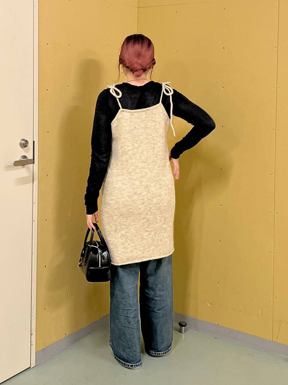 シルバー系のパンプス、ブルー系のデニムパンツ、ブラック系のTシャツ/カットソーを着用したレディースの秋コーディネートの2枚目の写真