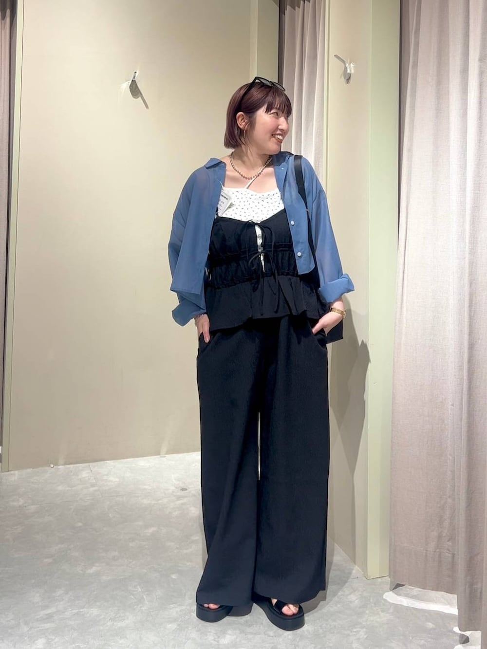 ブラック系のショルダーバッグ、ブルー系のシャツ/ブラウス、ブラック系のサンダルを着用したレディースの夏コーディネートの4枚目の写真