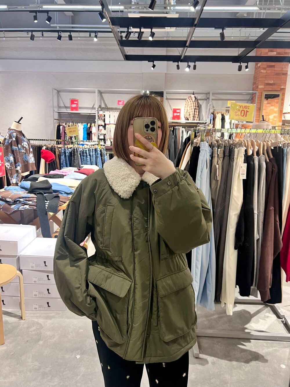 グリーン系のその他アウター、ブラック系のサンダル、ブルー系のその他パンツを着用したレディースの冬コーディネートの4枚目の写真