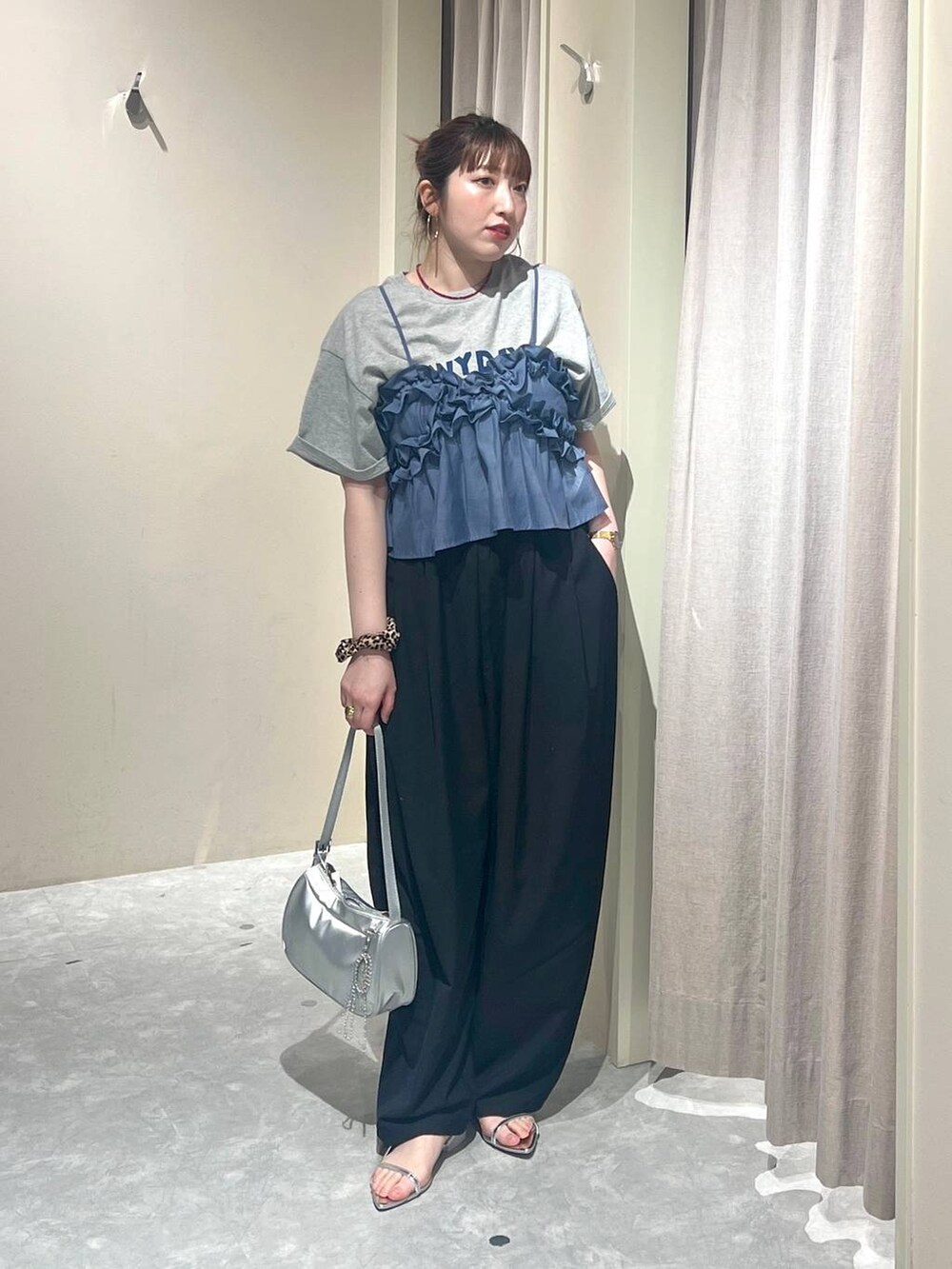 ブルー系のキャミソール、シルバー系のトートバッグ、シルバー系のサンダルを着用したレディースの春コーディネートの4枚目の写真