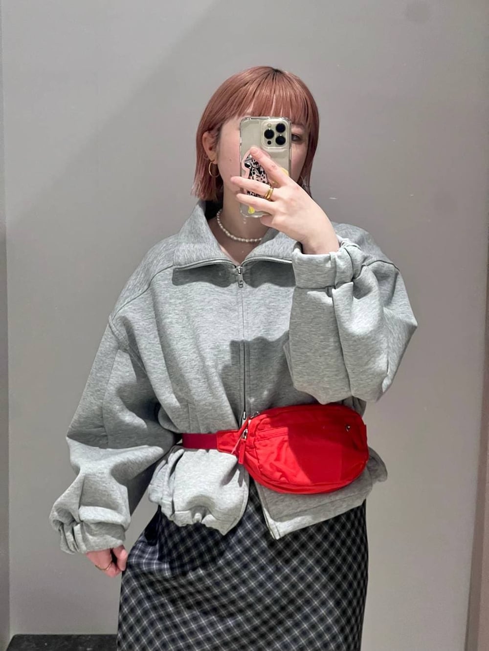 レッド系のボディバッグ/ウエストポーチ、グレー系のスカート、グレー系のスウェットを着用したレディースの冬コーディネートの4枚目の写真
