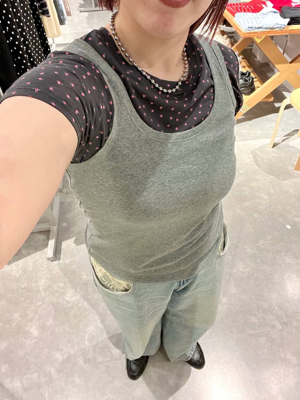 グレー系のタンクトップ、ブルー系のデニムパンツ、ブラック系のローファーを着用したレディースの夏コーディネートの4枚目の写真