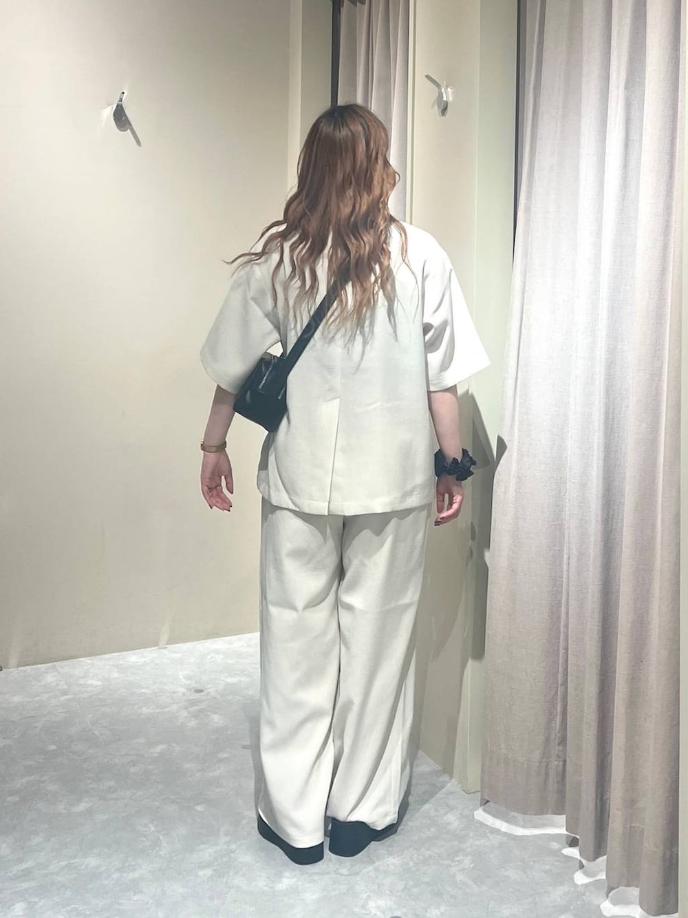 ホワイト系のテーラードジャケット、ホワイト系のその他パンツ、ブラック系のサンダルを着用したレディースの夏コーディネートの3枚目の写真