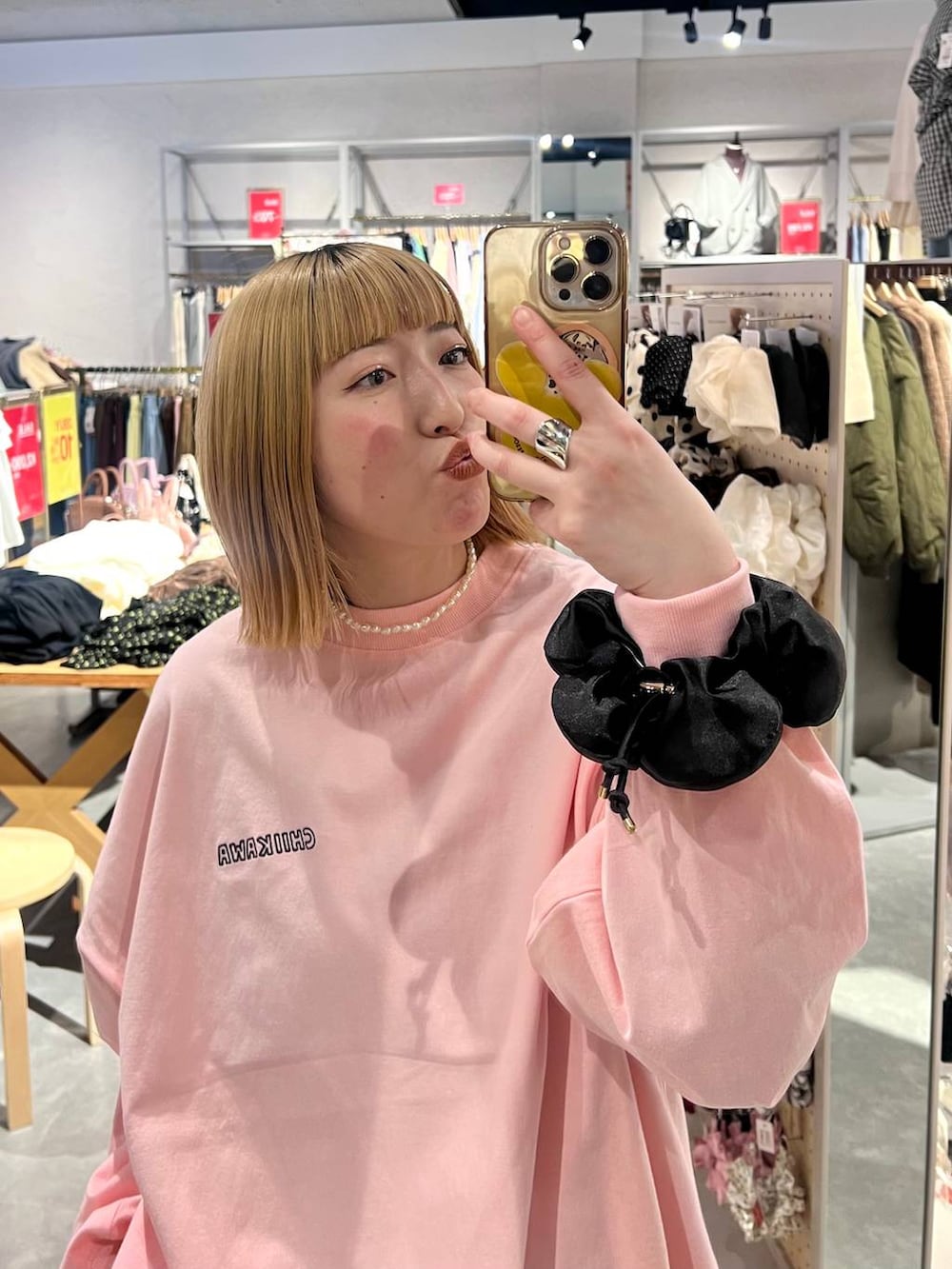 ブラック系のスカート、ピンク系のTシャツ/カットソー、ブラック系のシュシュを着用したレディースの冬コーディネートの4枚目の写真