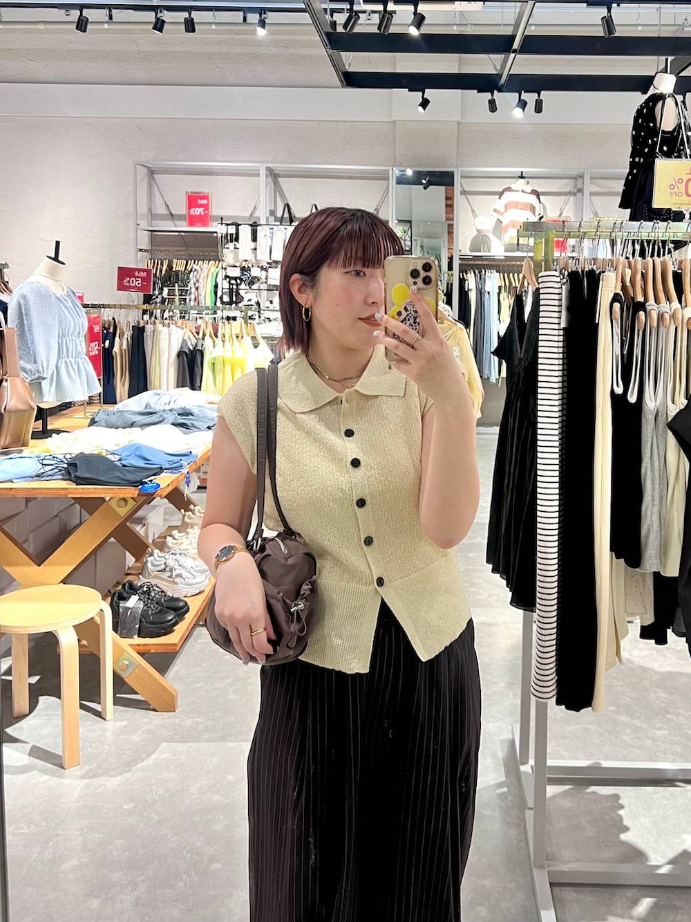 ホワイト系のベスト、ブラウン系のその他パンツ、ブラック系のサンダルを着用したレディースの夏コーディネートの2枚目の写真