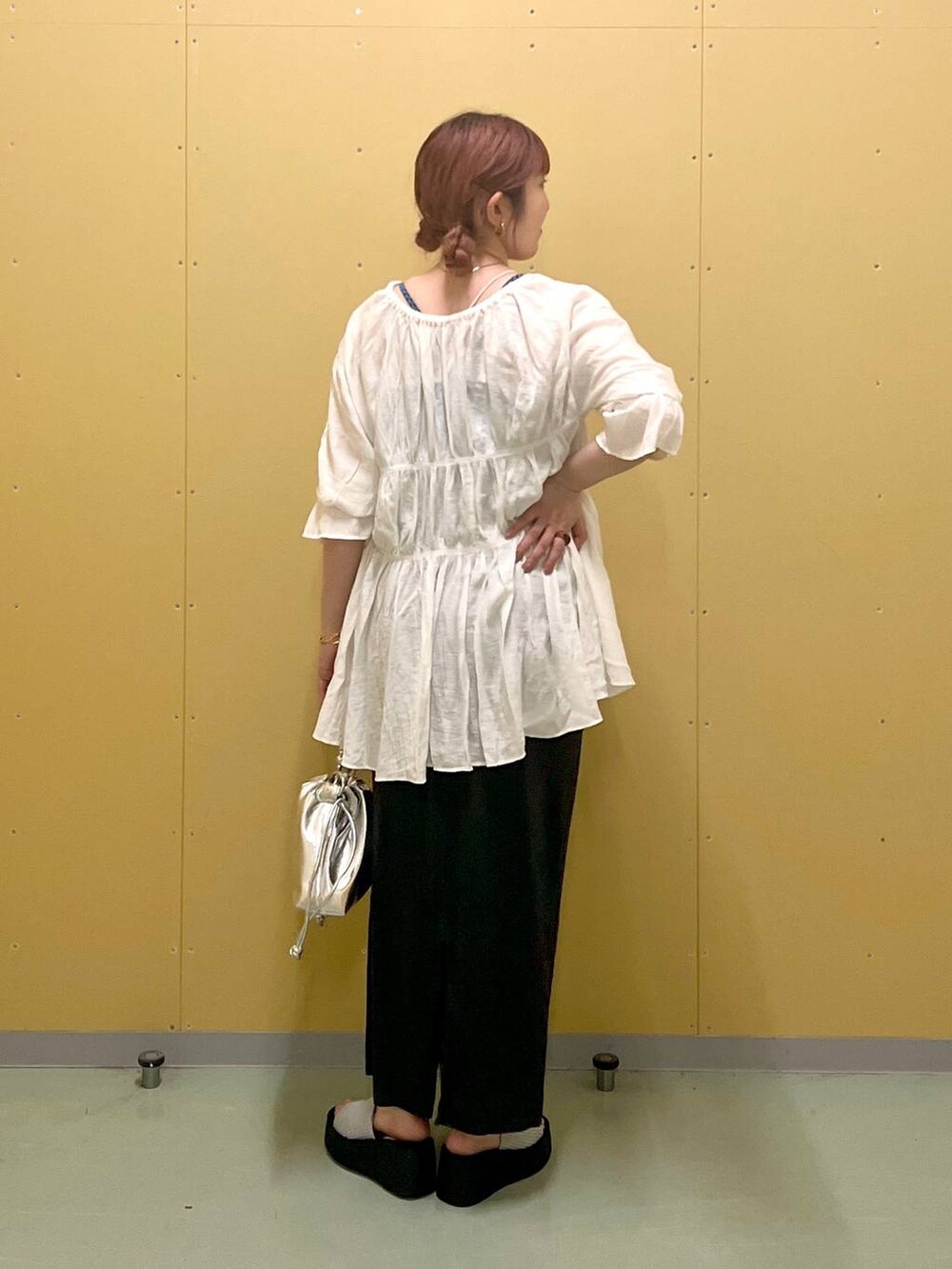 グレー系のスカート、シルバー系のショルダーバッグ、シルバー系のサンダルを着用したレディースの夏コーディネートの2枚目の写真