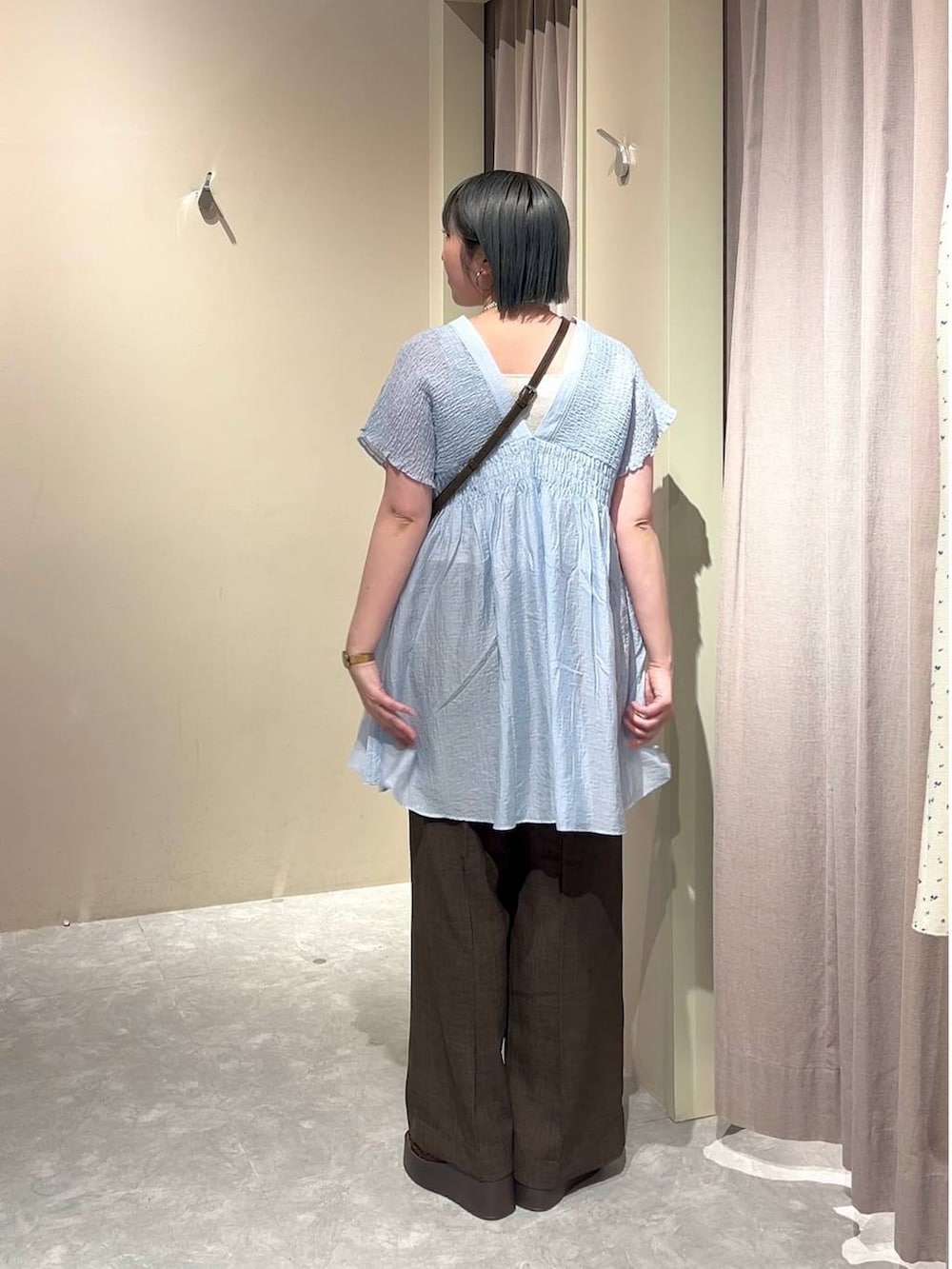 シルバー系のタンクトップ、ブルー系のシャツ/ブラウス、ブラウン系のスラックスを着用したレディースの春コーディネートの3枚目の写真