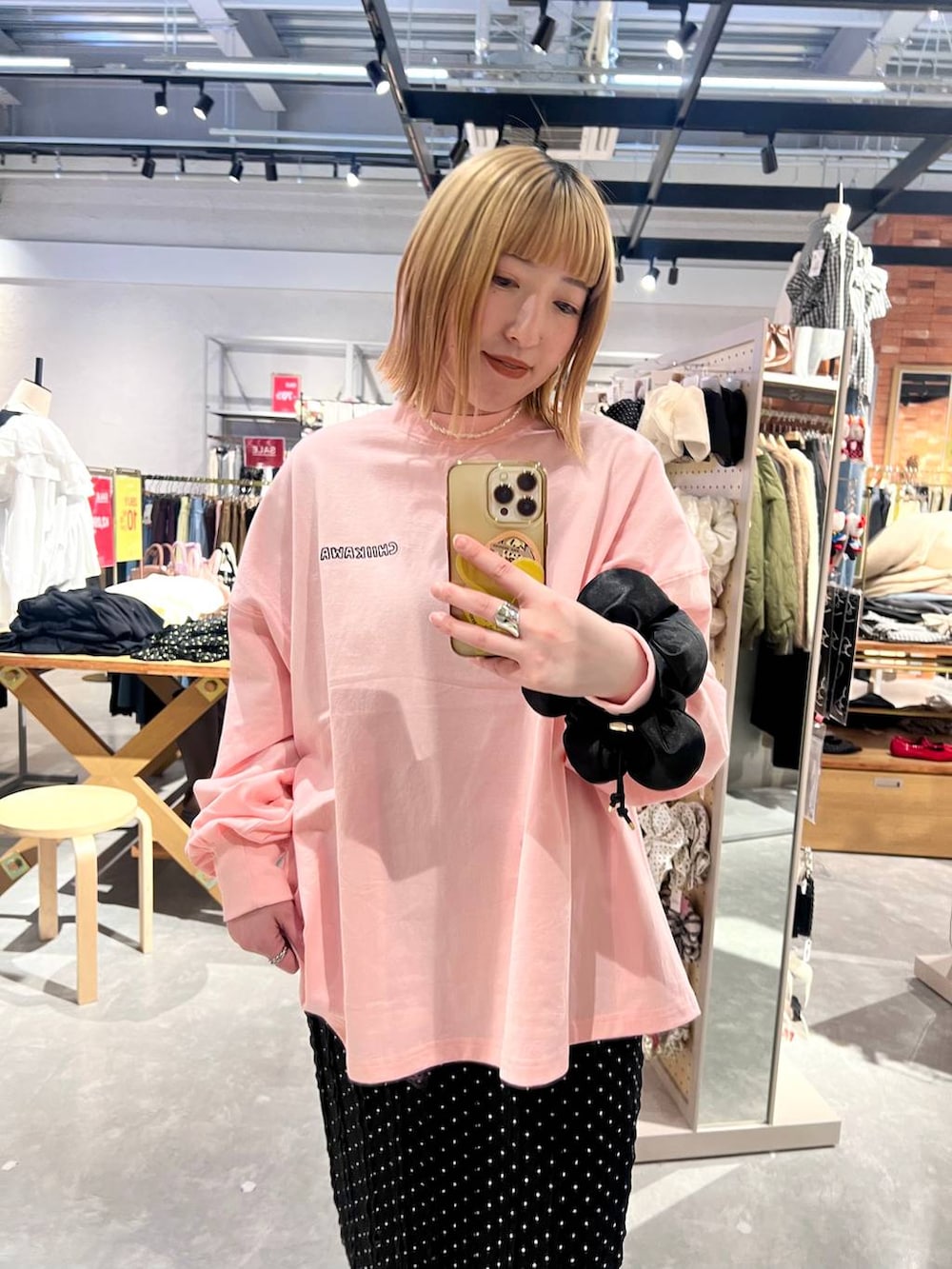 ブラック系のスカート、ピンク系のTシャツ/カットソー、ブラック系のシュシュを着用したレディースの冬コーディネートの7枚目の写真