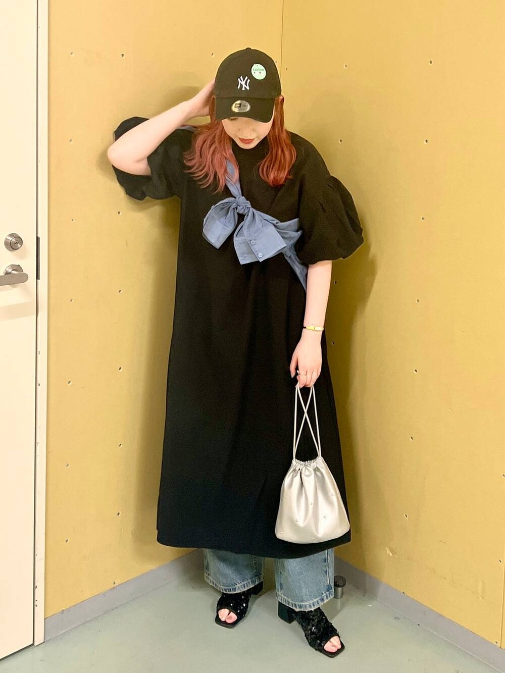 ブラック系のワンピース、シルバー系のショルダーバッグ、ブルー系のデニムパンツを着用したレディースの夏コーディネートの4枚目の写真