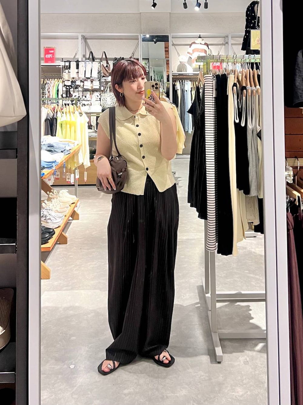 ホワイト系のベスト、ブラウン系のその他パンツ、ブラック系のサンダルを着用したレディースの夏コーディネートの3枚目の写真