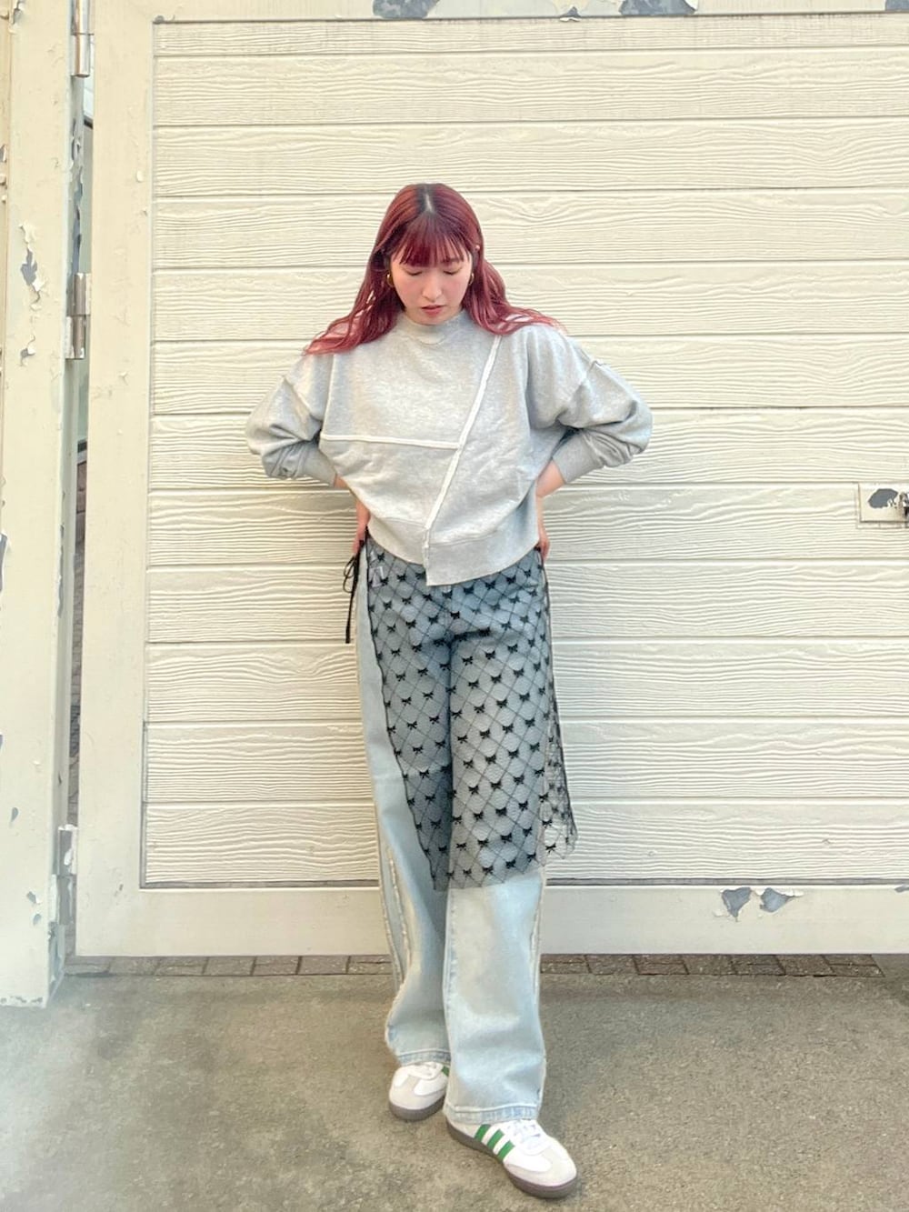 ブルー系のデニムパンツ、グレー系のスウェット、シルバー系のピアス(両耳用)を着用したレディースの秋コーディネートの5枚目の写真