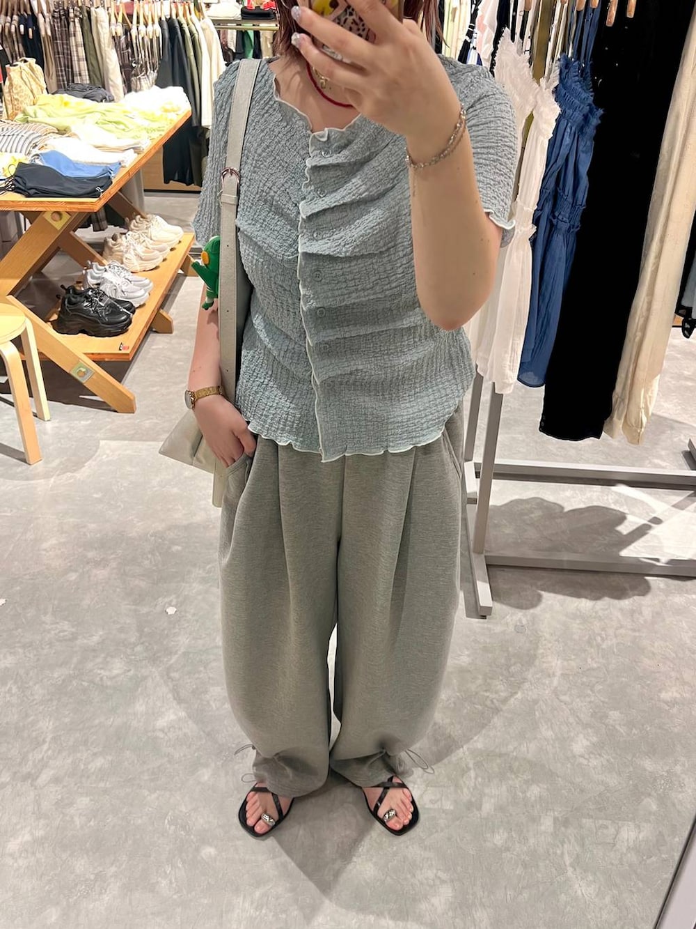 グレー系のスウェットパンツ、ブルー系のカーディガン/ボレロ、シルバー系のショルダーバッグを着用したレディースの夏コーディネートの5枚目の写真