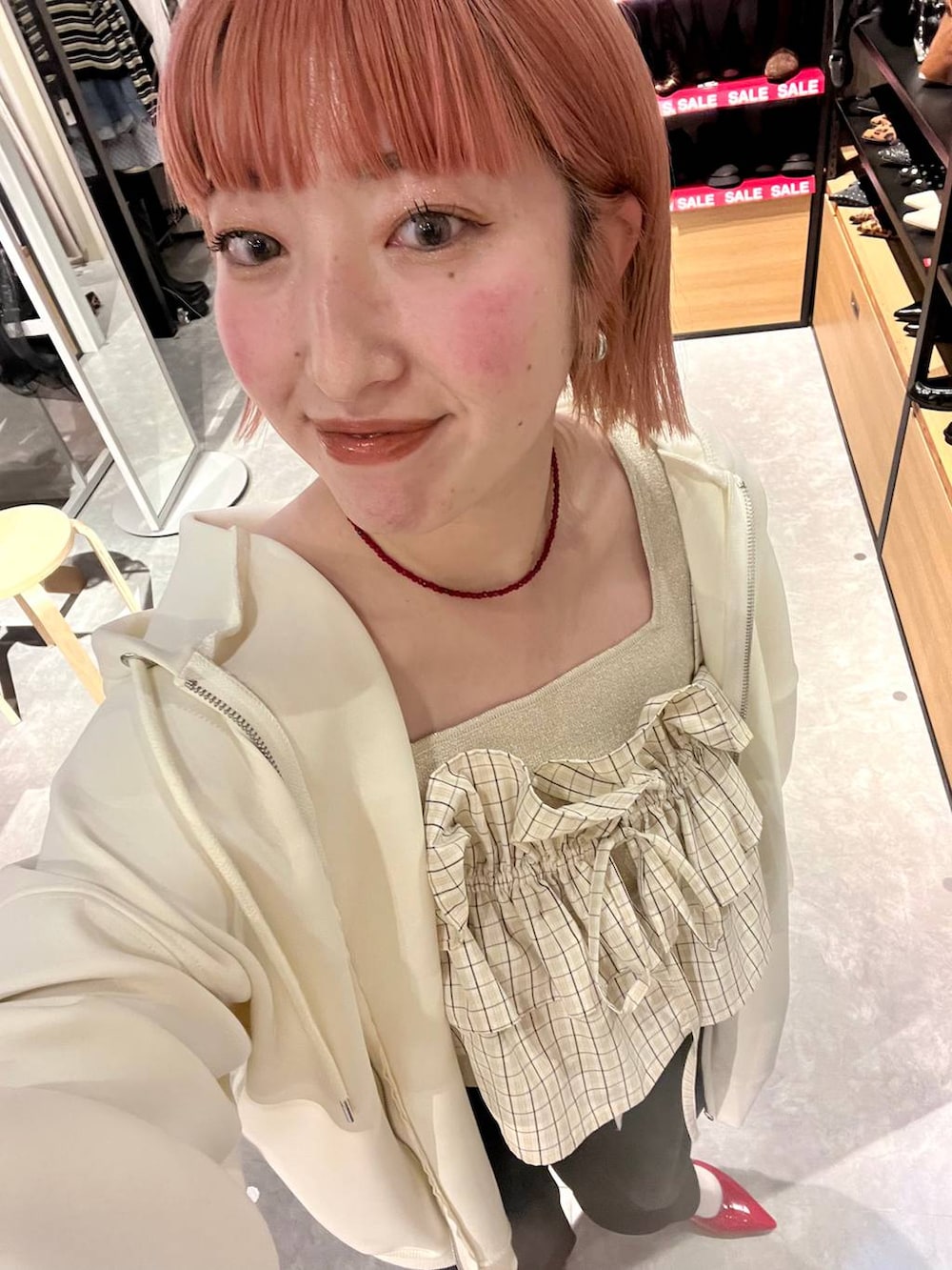 ブラック系のスウェットパンツ、ゴールド系のタンクトップ、ベージュ系のパーカーを着用したレディースの冬コーディネートの6枚目の写真