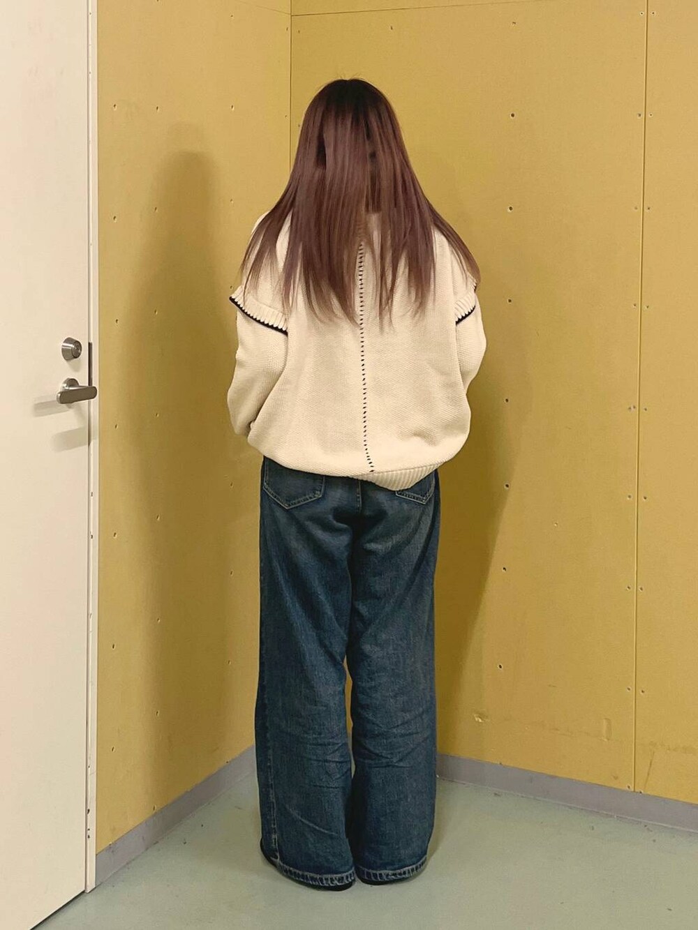 ホワイト系のニット/セーター、シルバー系のローファー、ブルー系のデニムパンツを着用したレディースの冬コーディネートの3枚目の写真