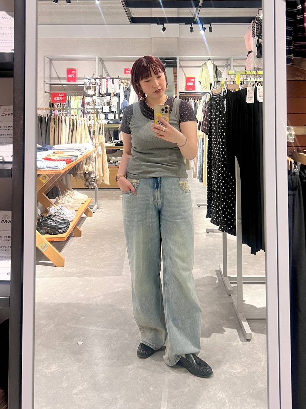 グレー系のタンクトップ、ブルー系のデニムパンツ、ブラック系のローファーを着用したレディースの夏コーディネートの2枚目の写真