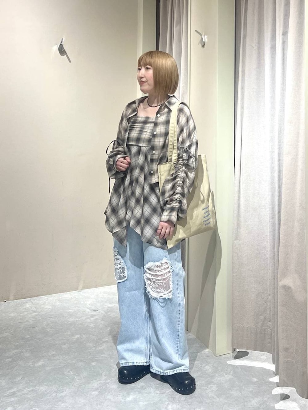 ブルー系のデニムパンツ、ベージュ系のトートバッグ、ブラック系のサンダルを着用したレディースの春コーディネートの4枚目の写真