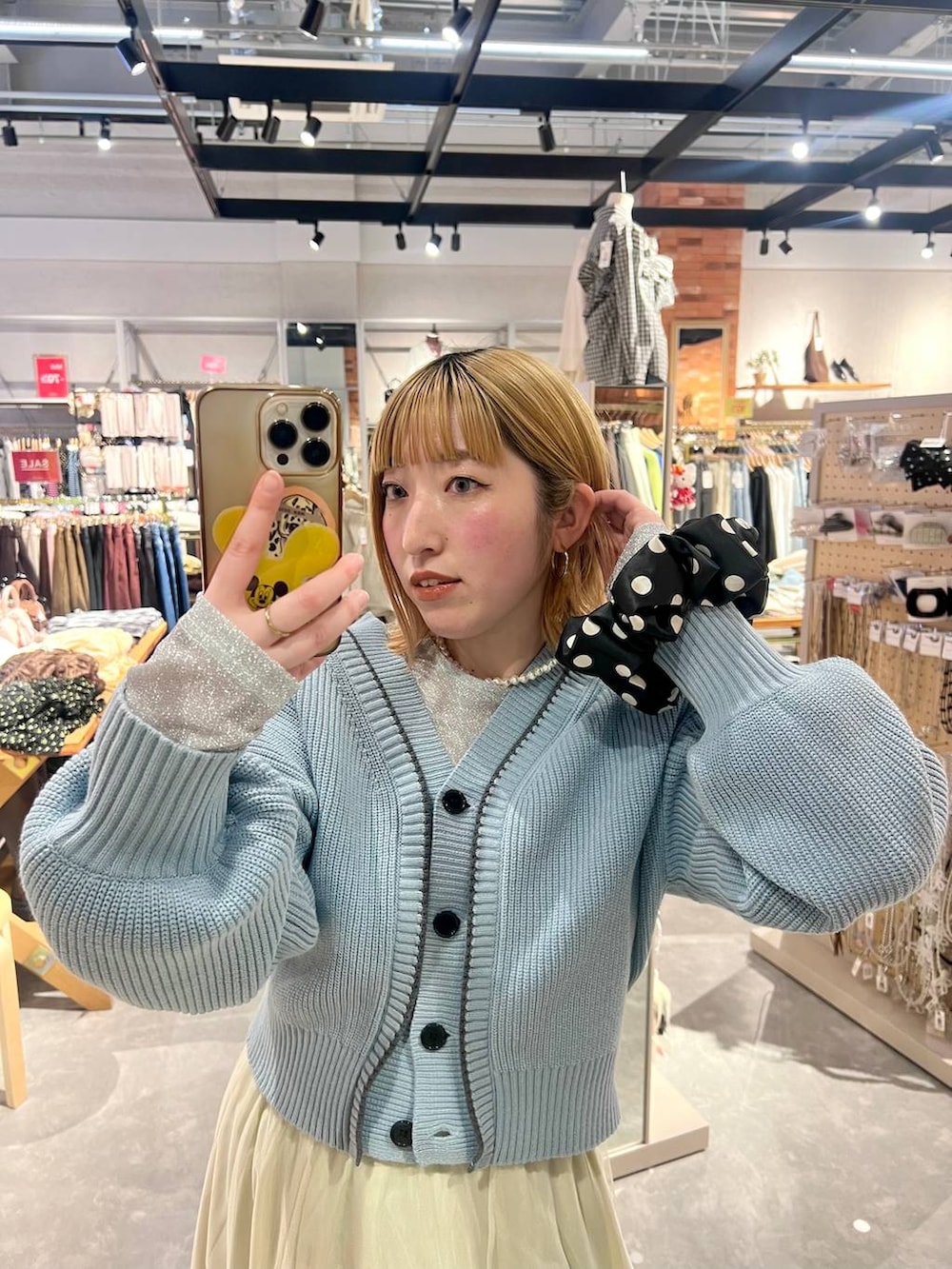 ブルー系のカーディガン/ボレロ、ブラック系のパンプス、ブルー系のデニムパンツを着用したレディースの冬コーディネートの5枚目の写真