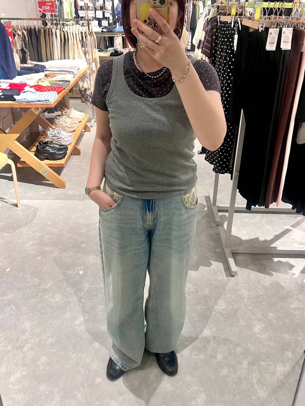 グレー系のタンクトップ、ブルー系のデニムパンツ、ブラック系のローファーを着用したレディースの夏コーディネートの6枚目の写真