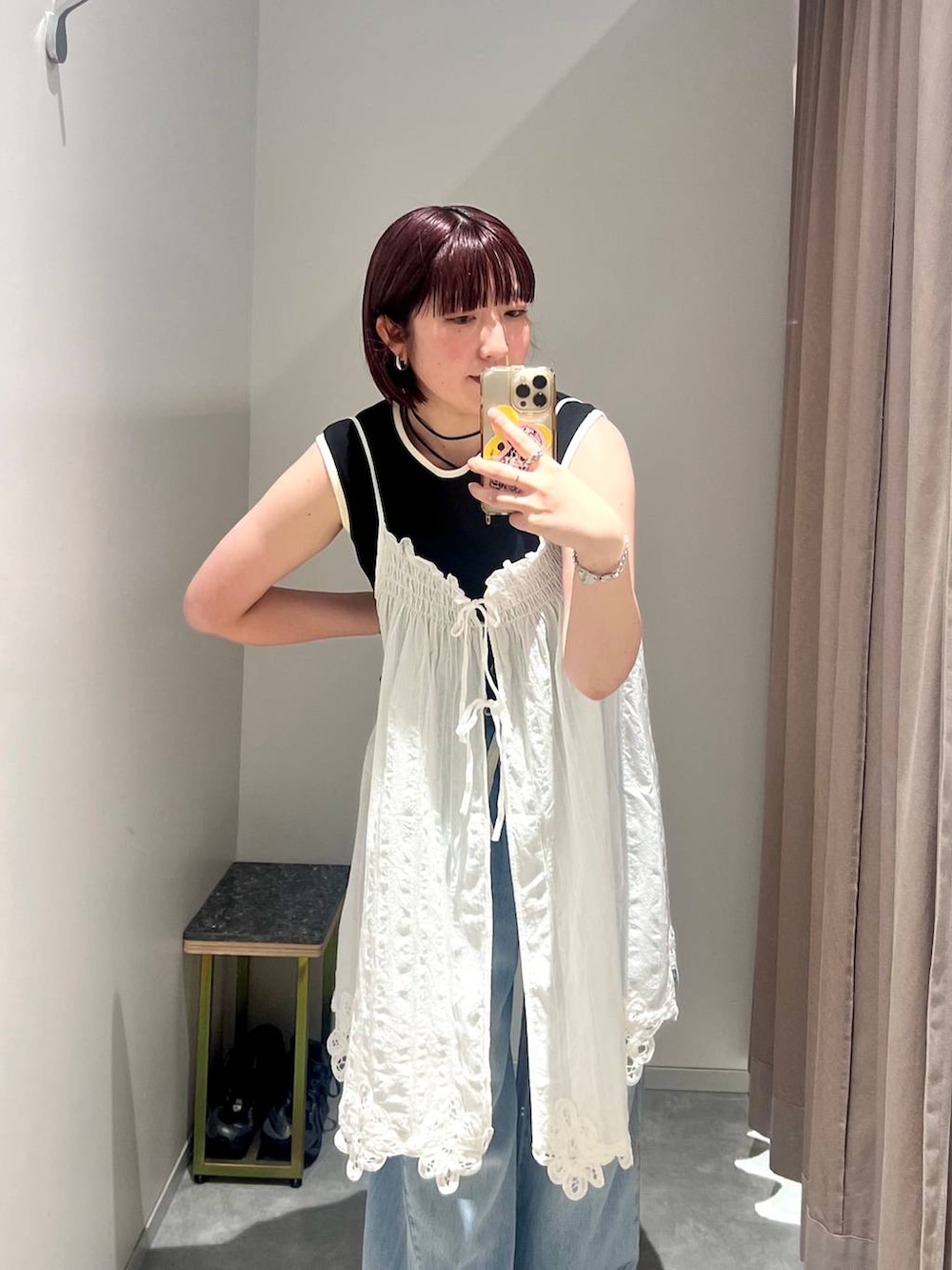 ブラック系のタンクトップ、ブルー系のデニムパンツ、ブラック系のサンダルを着用したレディースの夏コーディネートの4枚目の写真