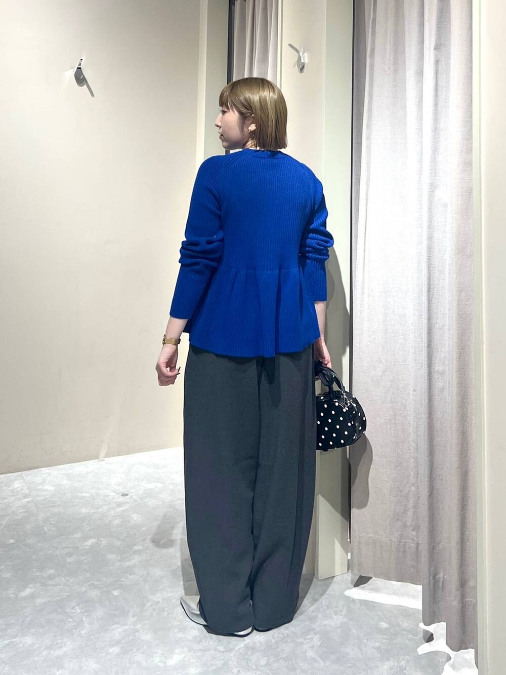 グレー系のその他パンツ、シルバー系のパンプス、その他のボストンバッグを着用したレディースの秋コーディネートの3枚目の写真