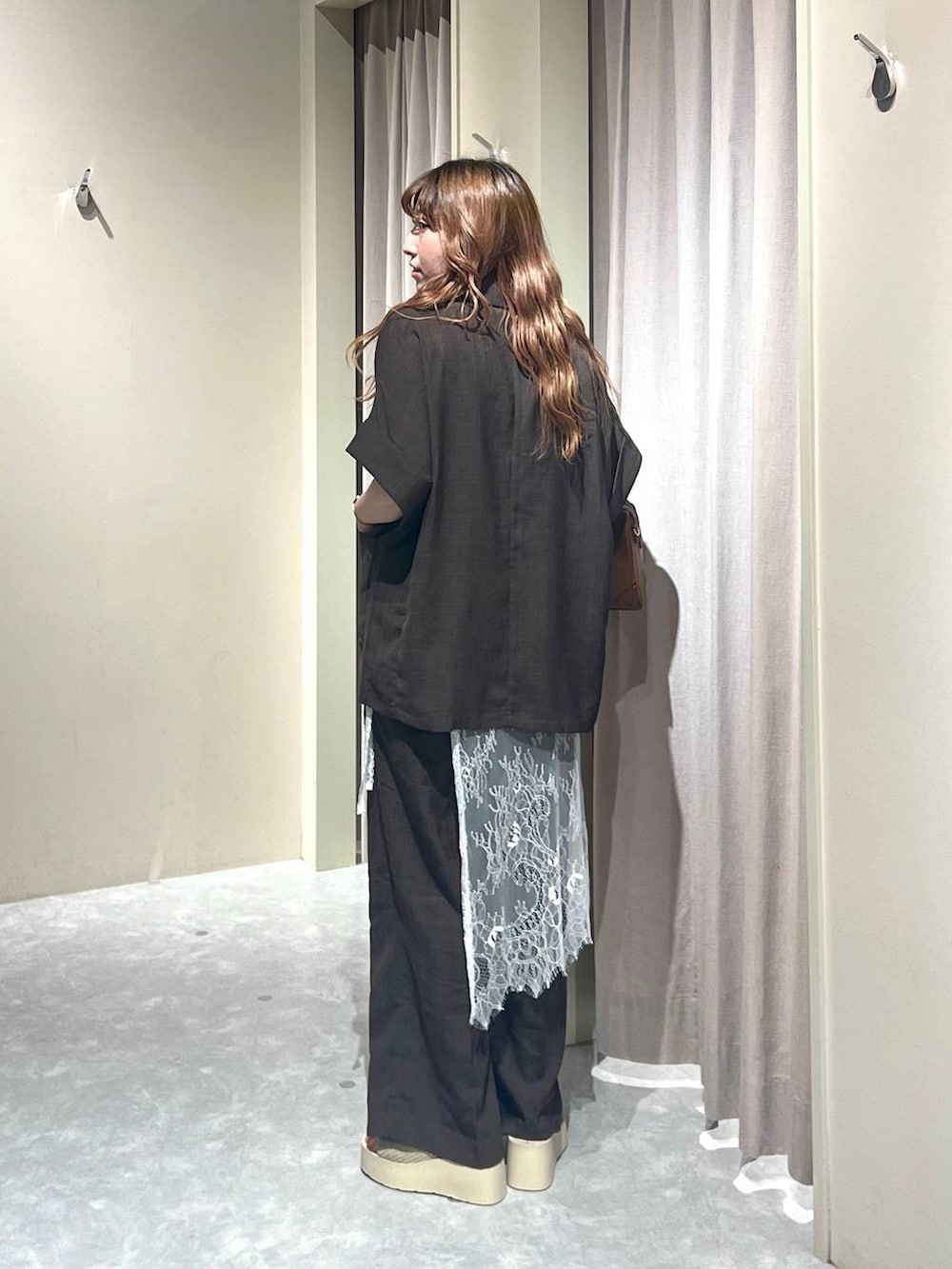 ホワイト系のTシャツ/カットソー、ホワイト系のサンダル、ブラウン系のテーラードジャケットを着用したレディースの秋コーディネートの3枚目の写真