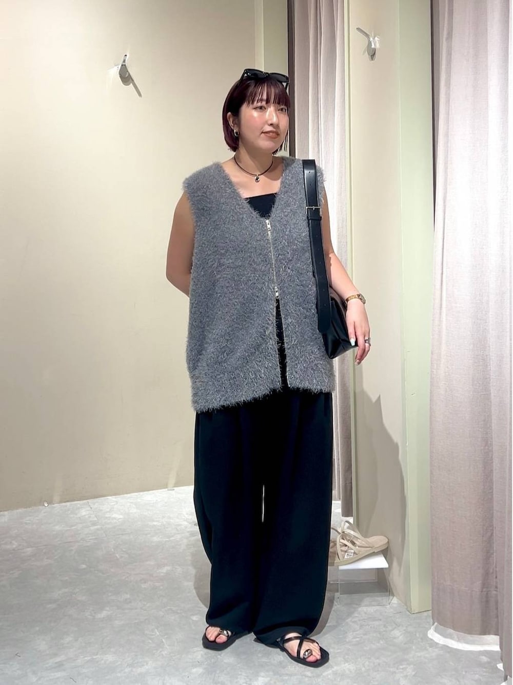 ブラック系のショルダーバッグ、ブラック系のスウェットパンツ、ブラック系のタンクトップを着用したレディースの秋コーディネートの7枚目の写真