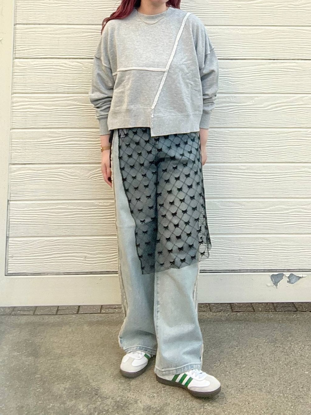 ブルー系のデニムパンツ、グレー系のスウェット、シルバー系のピアス(両耳用)を着用したレディースの秋コーディネートの6枚目の写真