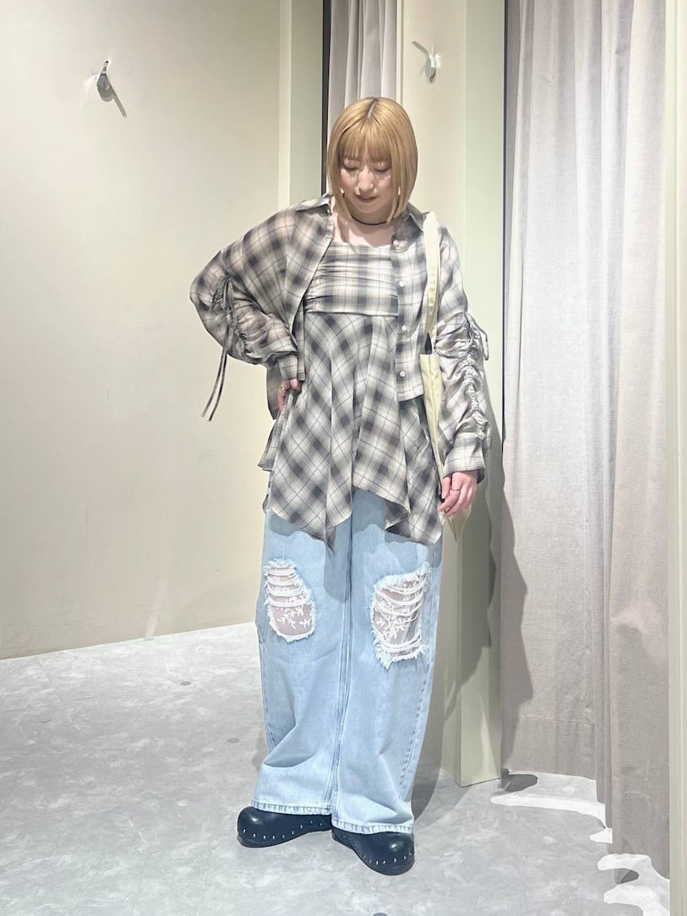 ブルー系のデニムパンツ、ベージュ系のトートバッグ、ブラック系のサンダルを着用したレディースの春コーディネートの5枚目の写真