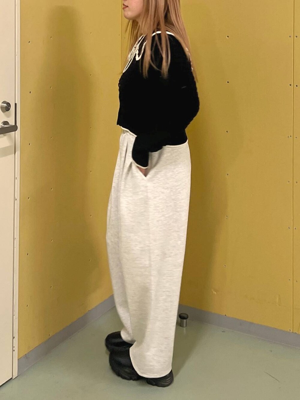 ブラック系のブーツ、ピンク系のショルダーバッグ、ブルー系のニット/セーターを着用したレディースの冬コーディネートの2枚目の写真