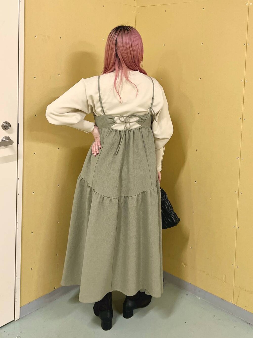 ブラック系のブーツ、ホワイト系のニット/セーター、ブラック系のショルダーバッグを着用したレディースの冬コーディネートの3枚目の写真