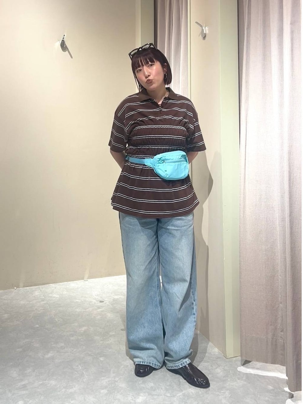 ブルー系のデニムパンツ、ブルー系のボディバッグ/ウエストポーチ、ブラウン系のローファーを着用したレディースの春コーディネートの4枚目の写真