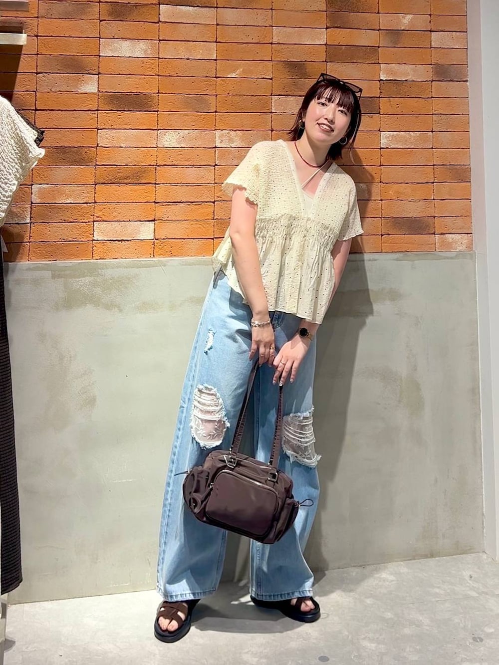 ブルー系のデニムパンツ、ブラウン系のサンダル、その他のシャツ/ブラウスを着用したレディースの夏コーディネートの4枚目の写真