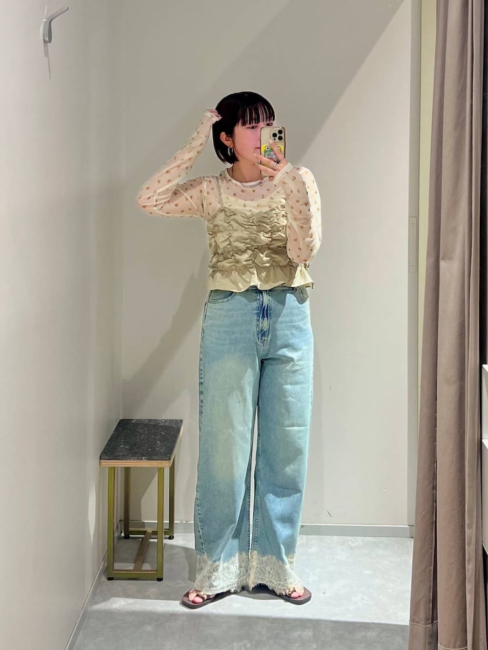 ベージュ系のベスト、ブルー系のデニムパンツ、ブラウン系のサンダルを着用したレディースの夏コーディネートの5枚目の写真