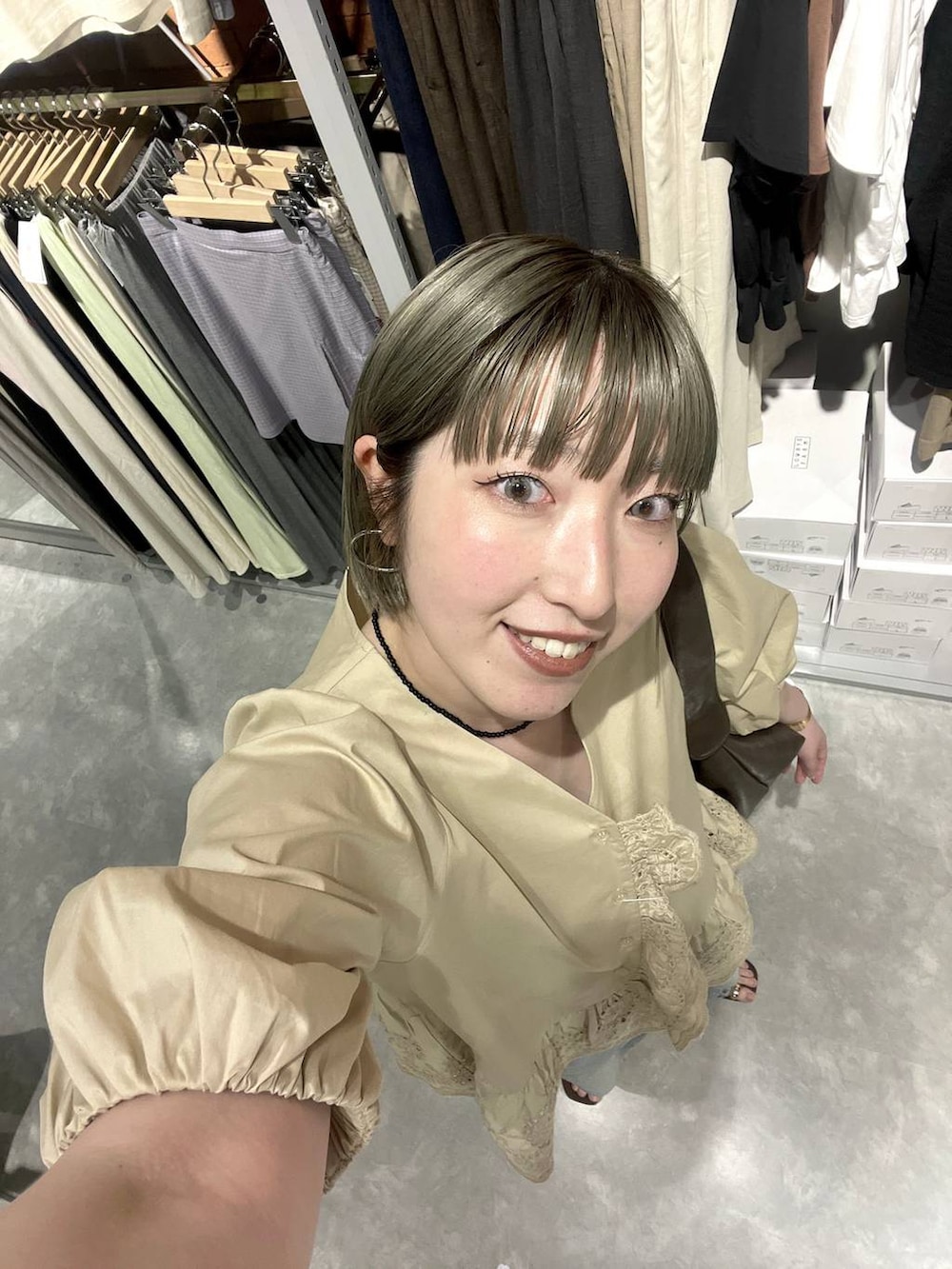 ブルー系のデニムパンツ、ブラウン系のサンダル、ベージュ系のシャツ/ブラウスを着用したレディースの春コーディネートの6枚目の写真
