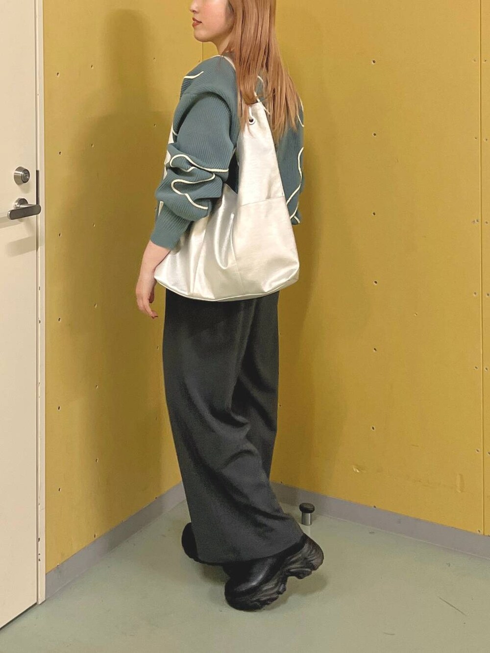 ブラック系のブーツ、シルバー系のトートバッグ、グレー系のその他パンツを着用したレディースの冬コーディネートの2枚目の写真