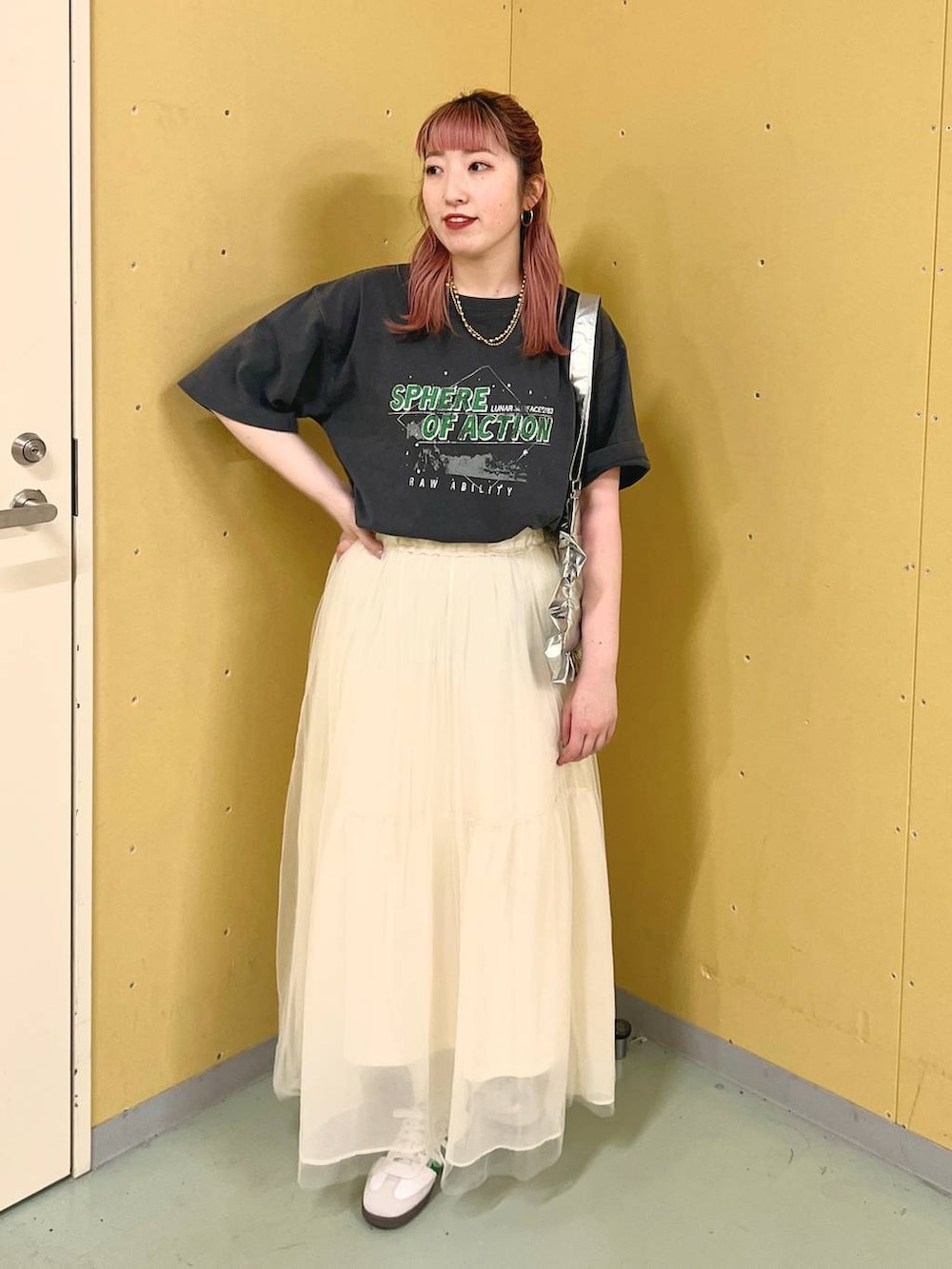 グレー系のTシャツ/カットソー、ホワイト系のスカート、シルバー系のショルダーバッグを着用したレディースの春コーディネートの6枚目の写真