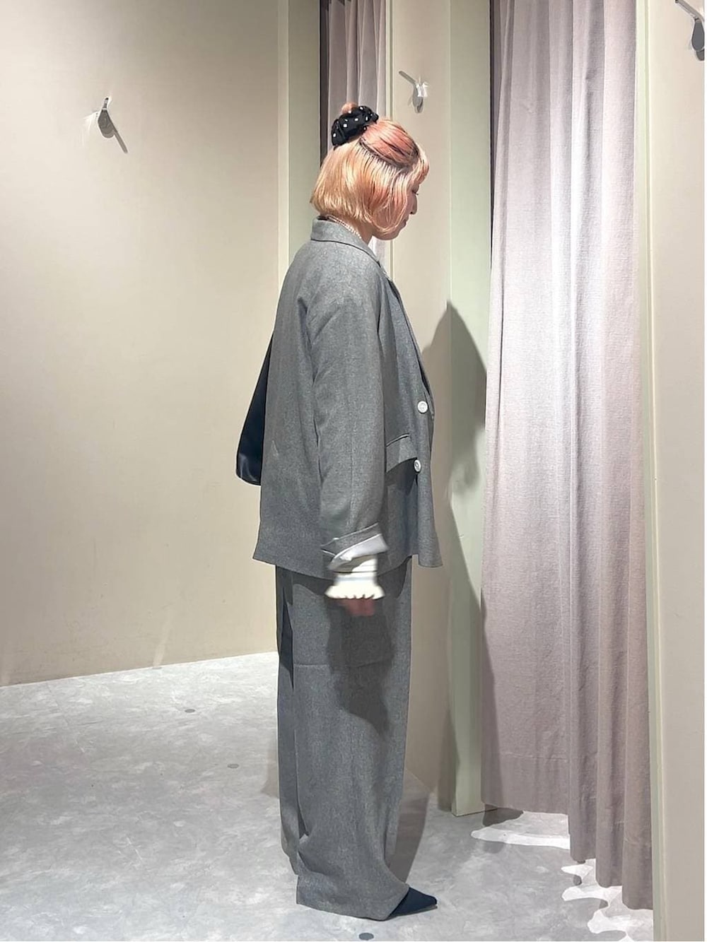 ブラック系のショルダーバッグ、グレー系のテーラードジャケット、グレー系のデニムパンツを着用したレディースの春コーディネートの2枚目の写真