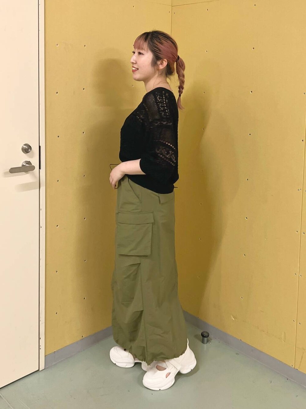 ホワイト系のサンダル、グリーン系のスカート、ブラック系のカーディガン/ボレロを着用したレディースの夏コーディネートの2枚目の写真