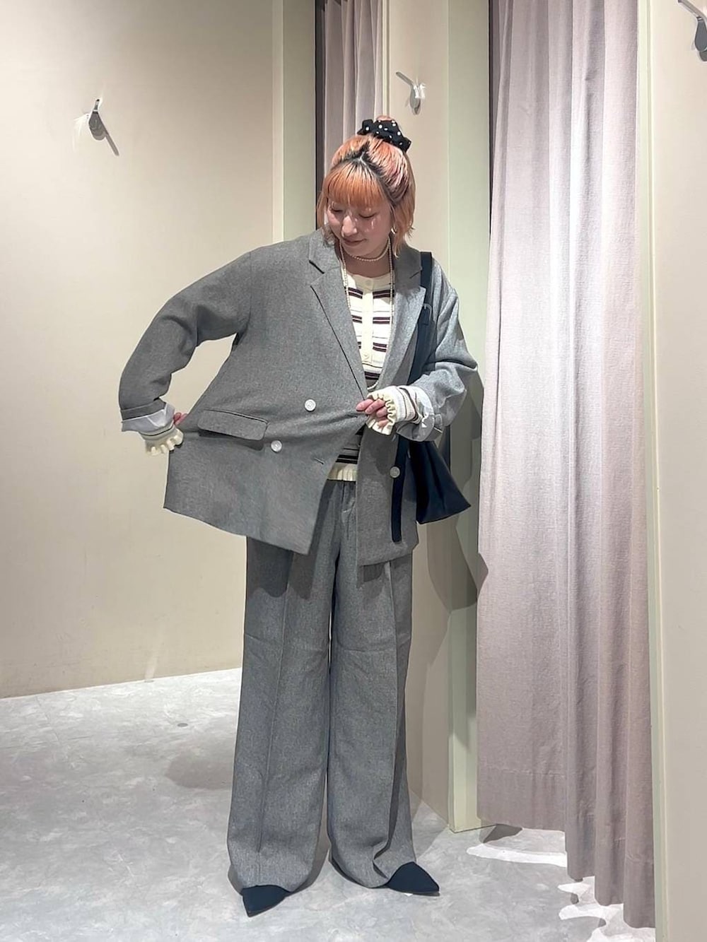 ブラック系のショルダーバッグ、グレー系のテーラードジャケット、グレー系のデニムパンツを着用したレディースの春コーディネートの5枚目の写真