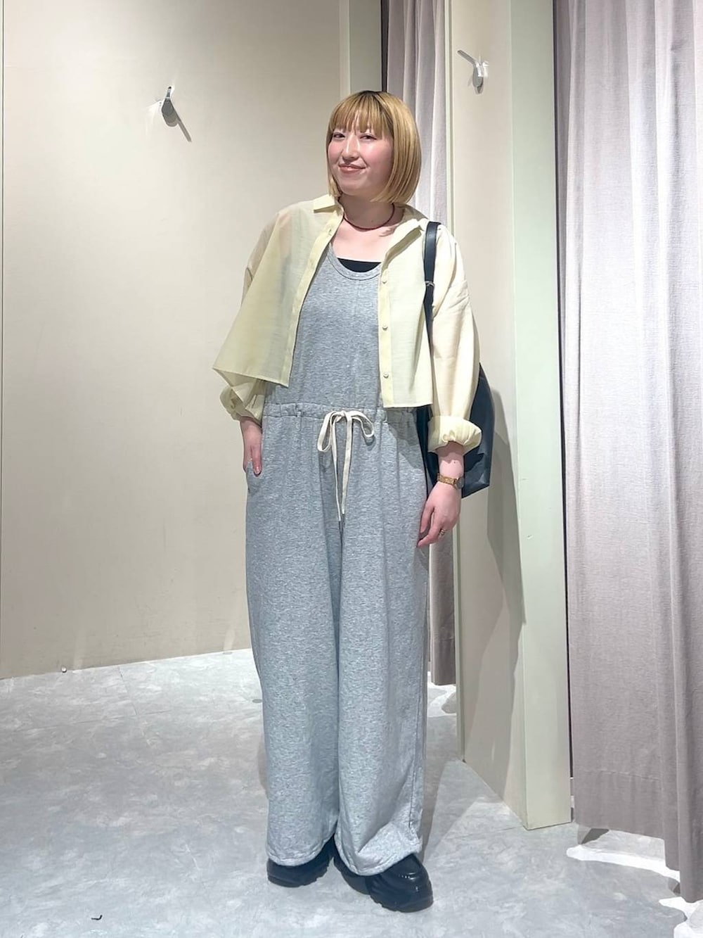 ブラック系のショルダーバッグ、イエロー系のシャツ/ブラウス、ブラック系のローファーを着用したレディースの春コーディネートの3枚目の写真