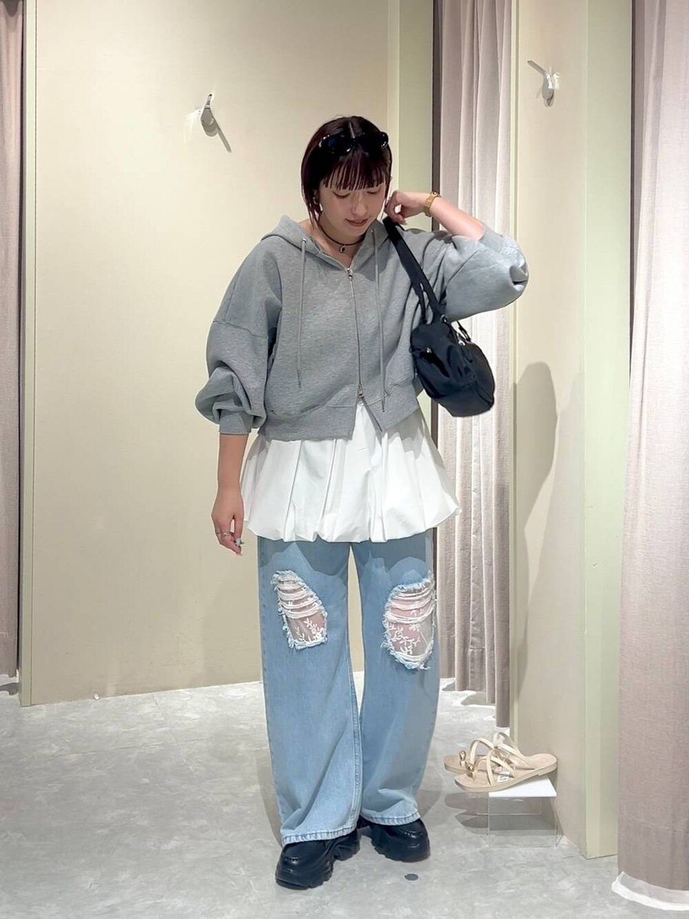 グレー系のパーカー、ブルー系のデニムパンツ、ブラック系のローファーを着用したレディースの秋コーディネートの6枚目の写真