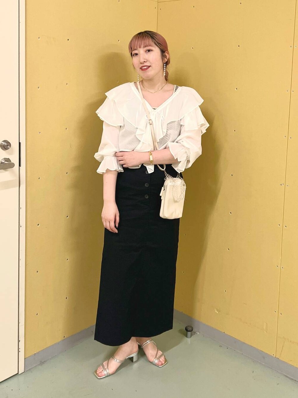 ベージュ系のショルダーバッグ、ホワイト系のTシャツ/カットソー、ブラック系のスカートを着用したレディースの夏コーディネートの2枚目の写真