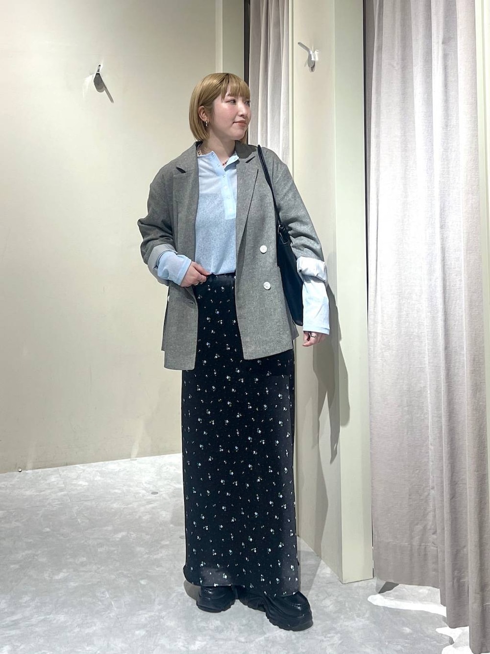 ブラック系のスカート、グレー系のテーラードジャケット、ブラック系のローファーを着用したレディースの春コーディネートの5枚目の写真