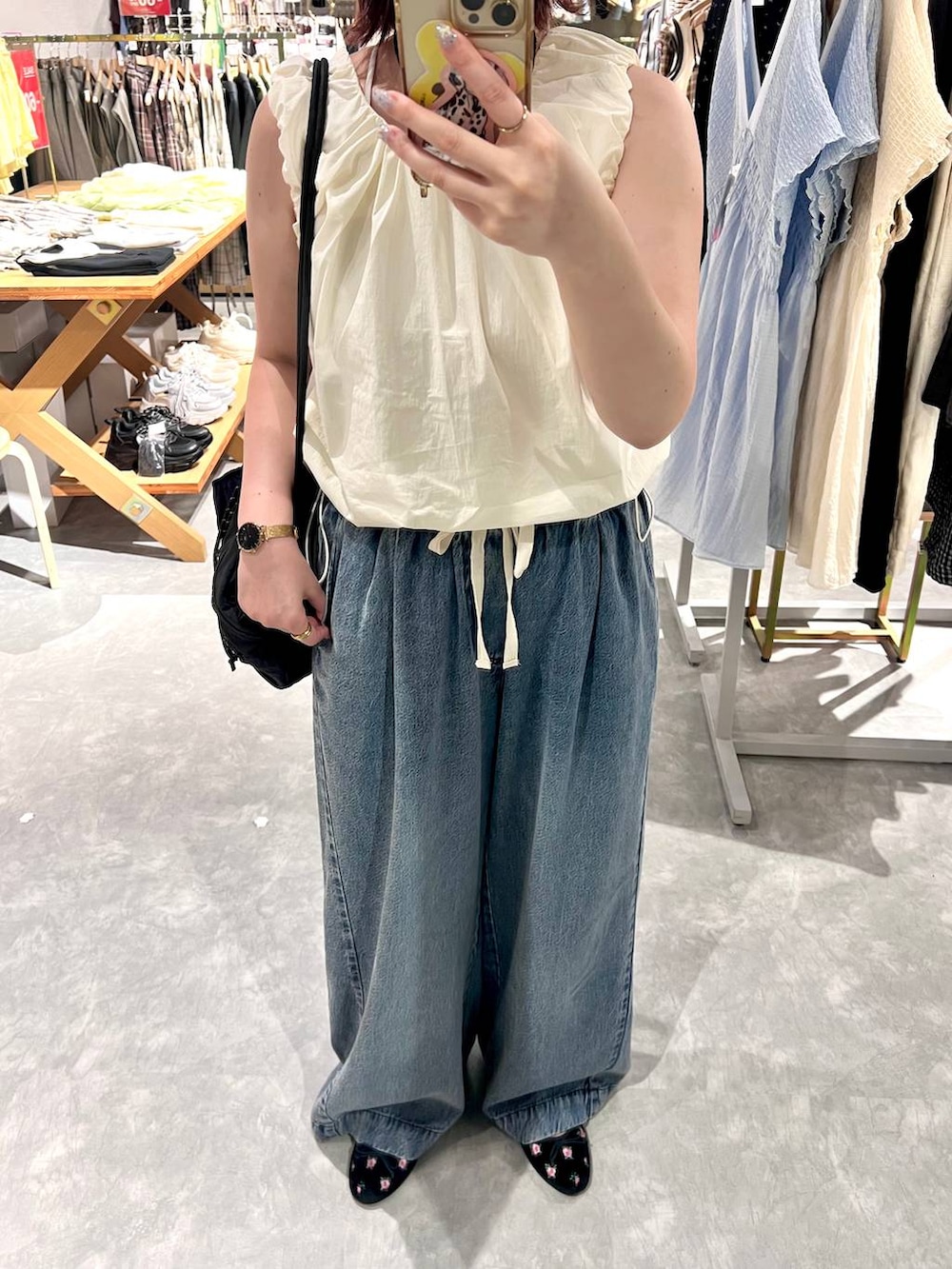 ホワイト系のシャツ/ブラウス、ブラック系のバレエシューズ、ブルー系のデニムパンツを着用したレディースの夏コーディネートの6枚目の写真
