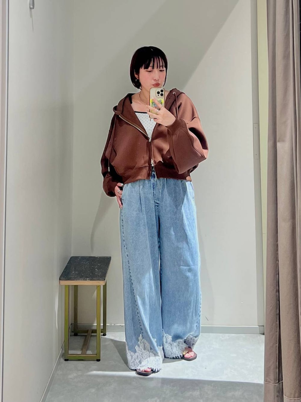 ホワイト系のキャミソール、ブルー系のデニムパンツ、ブラウン系のサンダルを着用したレディースの秋コーディネートの4枚目の写真