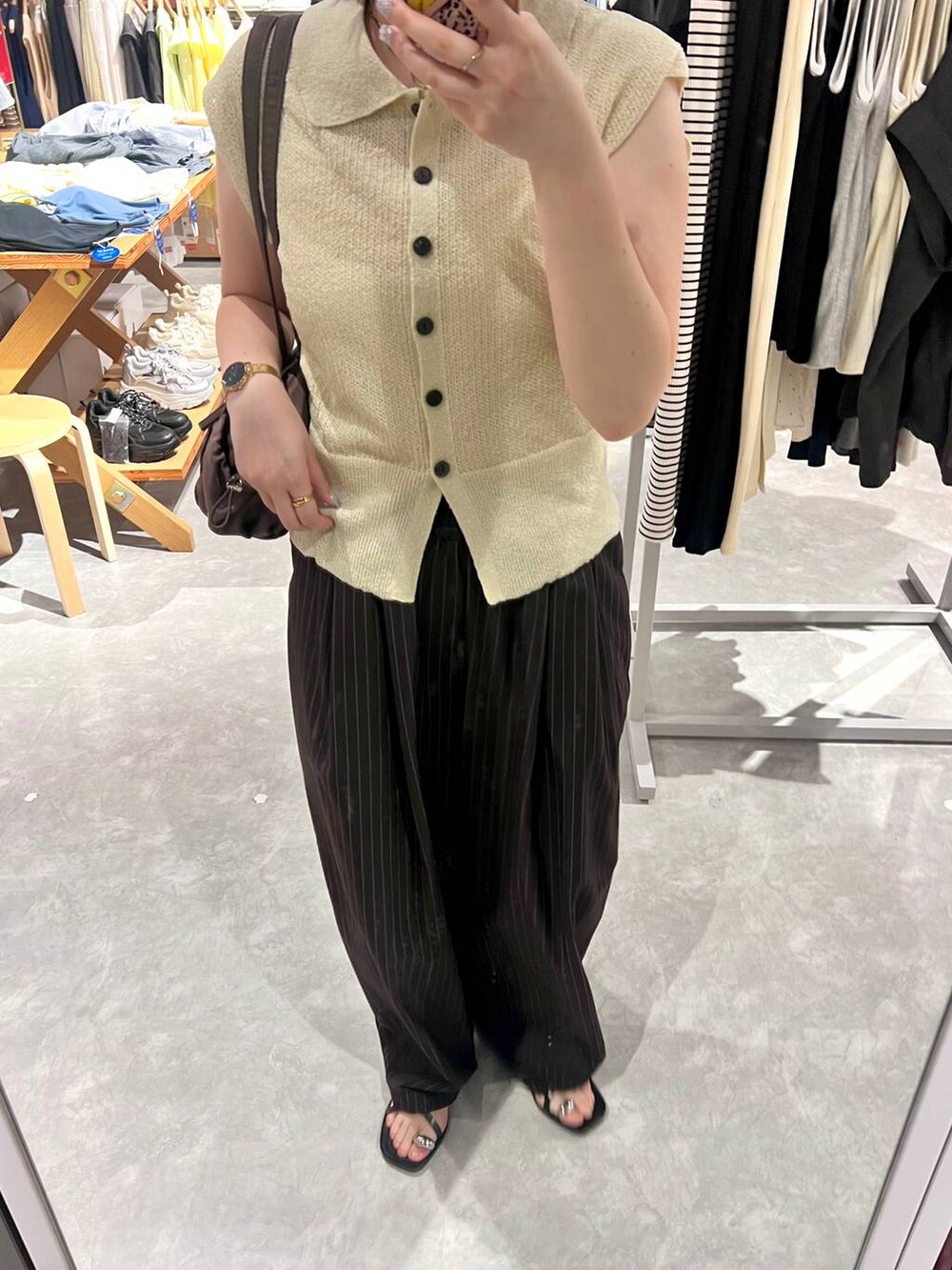 ホワイト系のベスト、ブラウン系のその他パンツ、ブラック系のサンダルを着用したレディースの夏コーディネートの4枚目の写真