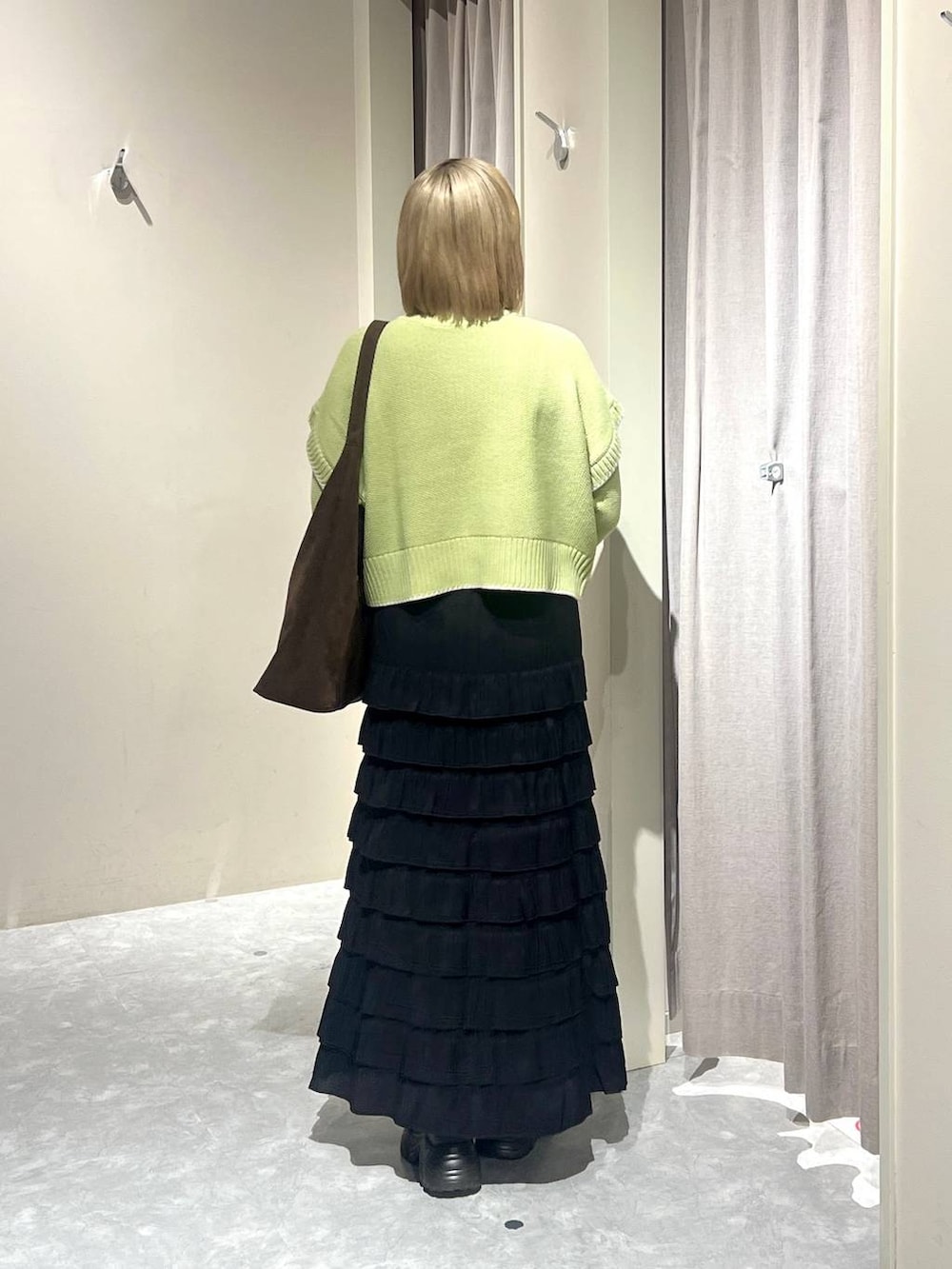 ブラウン系のショルダーバッグ、ブラック系のブーツ、グリーン系のニット/セーターを着用したレディースの冬コーディネートの3枚目の写真