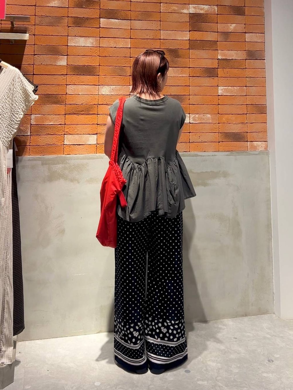 グレー系のTシャツ/カットソー、シルバー系のサンダル、レッド系のショルダーバッグを着用したレディースの夏コーディネートの3枚目の写真