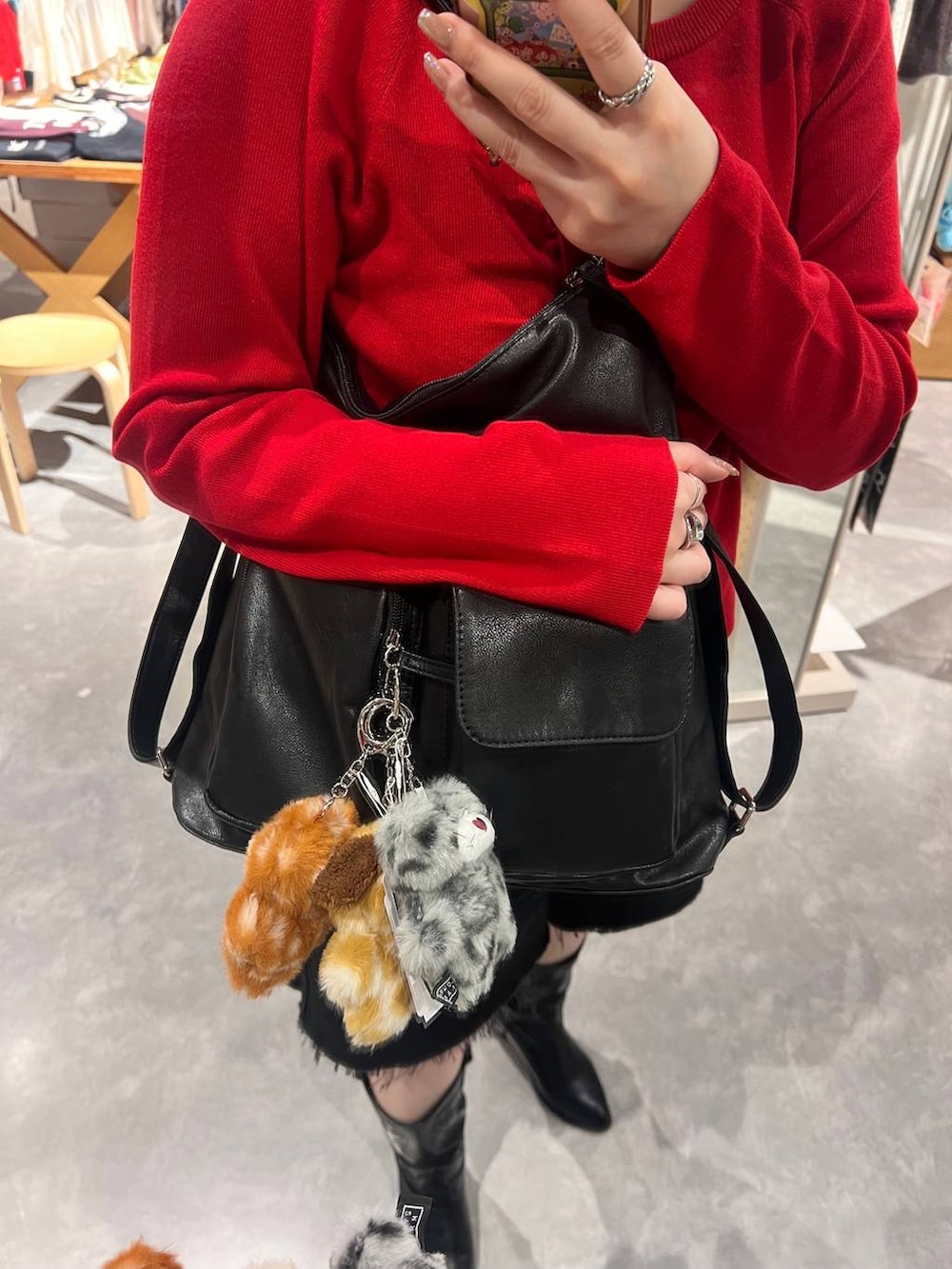 レッド系のニット/セーター、ブラック系のバックパック/リュック、その他のキーホルダーを着用したレディースの秋コーディネートの3枚目の写真